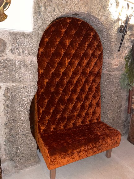 Eine elegante Sitzgelegenheit in Orange, umgeben von rustikalem Dekor, vermittelt ein behagliches Ambiente.