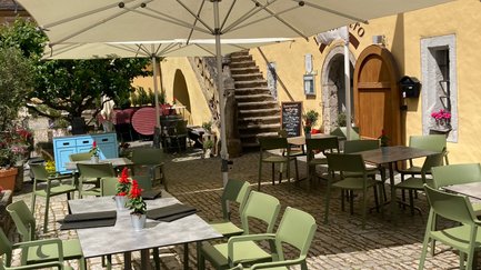 Eine charmante Atmosphäre auf einem gepflasterten Platz mit Stühlen und Tischen, bereit für ein geselliges Beisammensein.