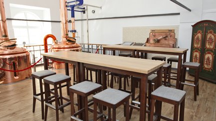 Bartisch mit sitzgepolsterten Barhockern umrandet