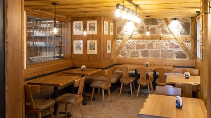 Eine gemütliche Restaurant-Ecke mit Holzstühlen und Tischen, die ein einladendes Ambiente schaffen.
