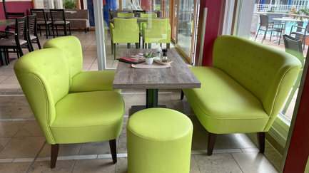 Ein modernes Café-Interieur mit lebhaften grünen Möbeln, das gemütliche Atmosphäre und stilvolle Einrichtung vermittelt.