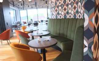 Die stilvolle Restaurant-Atmosphäre ist geprägt von einer geschwungenen grünen Bank und kreativen Wandverkleidungen.