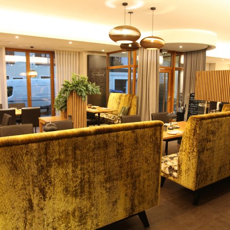 Stylishe Essumgebung mit luxuriösen, gepolsterten Bänken und klaren Linien, die einen modernen, eleganten Look vermittelt.