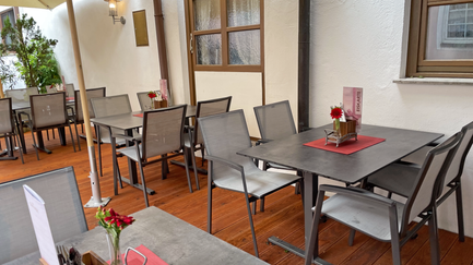 Ein einladender Außenbereich eines Cafés mit modernen Tischen und Stühlen