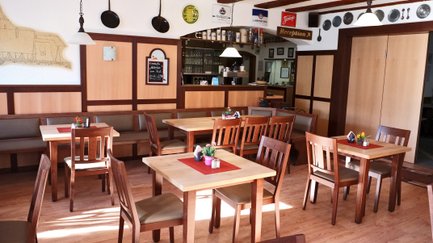 Restauranteinrichtung mit Stühlen, Tischen und Bänken im klassisch-hellem Holz-Stil