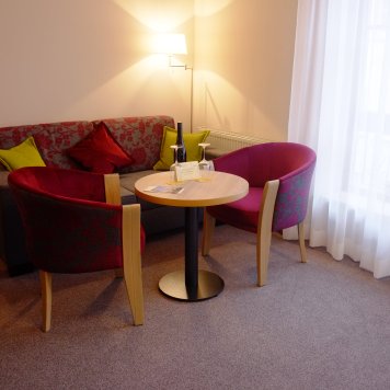 Ein stilvoll eingerichteter Raum mit einem Sofa, zwei Stühlen und einem Tisch, ideal für entspannte Momente.