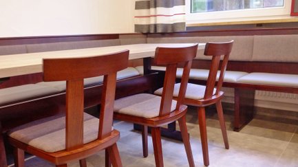 Der Raum zeigt eine moderne Einrichtung mit einem hellen Tisch und gepolsterten Bänken, die zum Verweilen einladen.