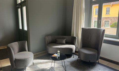 Gemütliche Sitzecke mit stilvollen, gepolsterten Sesseln und einem zeitgemäßen Tisch in einer modernen Lounge.