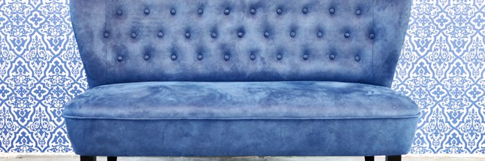 Blaue Sitzbank vor blauer Wand