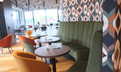 Die stilvolle Restaurant-Atmosphäre ist geprägt von einer geschwungenen grünen Bank und kreativen Wandverkleidungen.