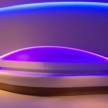 Weiße Sitzbank in lila ausgeleuchtetem Raum