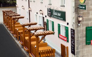 Das gemütliche Biergarten-Ambiente lädt mit Holzmöbeln und einer einladenden Fassade zum Verweilen ein.