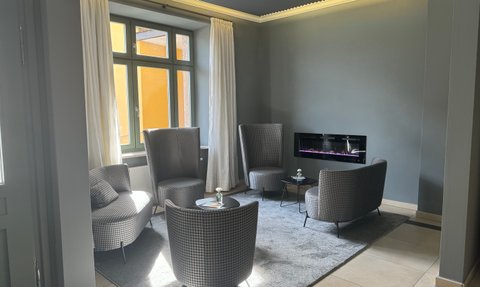 Gemütliche Sitzecke mit stilvollen, gepolsterten Sesseln und einem zeitgemäßen Tisch in einer modernen Lounge.