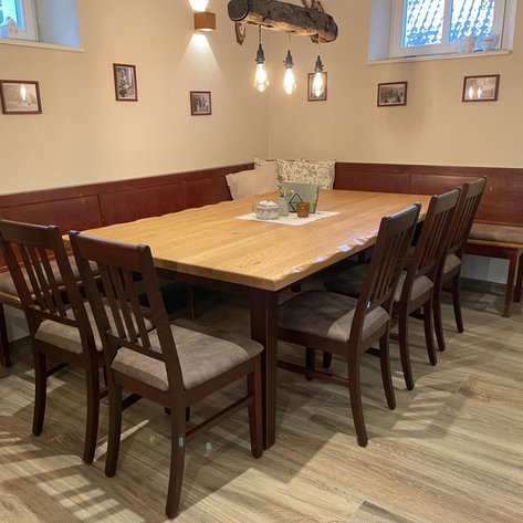 Verschiedene Platzmöglichkeiten im Restaurant, darunter ein gemütlicher Bereich mit Sitzbänke und charmanten Dekorationen.