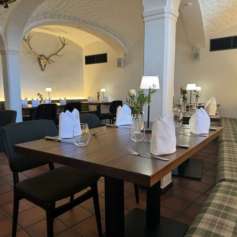 Ein gemütliches Restaurant mit eleganten Holztischen und bequemen Sitzbänken, bereit für Gäste.