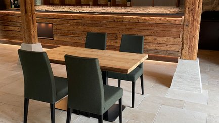 Ein Raum mit rustikalem Charme, ausgestattet mit einem massiven Holztisch und eleganten, bequemen Stühlen.