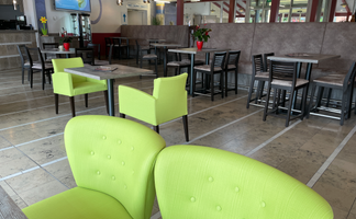 Ein modernes Café-Interieur mit lebhaften grünen Möbeln, das gemütliche Atmosphäre und stilvolle Einrichtung vermittelt.