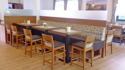 Das helle Restaurant bietet gemütliche Tische und eine moderne Inneneinrichtung mit warmen Holztönen.