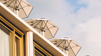 In einer Perspektive von unten nach oben schauend sind auf einem Dach stehen mehrere hellfarbenen, aufgespannte Schirme zu sehen. Am unteren Rand steht Glatz geschrieben.