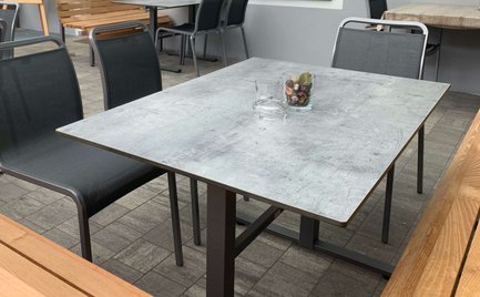 Gemütlicher Außenbereich mit Holz- und Metallmöbeln, der eine angenehme Atmosphäre für Gäste schafft.