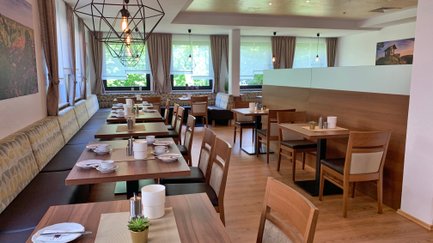 Das helle Restaurant bietet gemütliche Tische und eine moderne Inneneinrichtung mit warmen Holztönen.