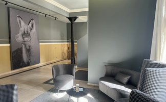 Ein eleganter Lounge-Bereich mit modernen Sesseln und einem großflächigen Kunstwerk eines Fuchses an der Wand.