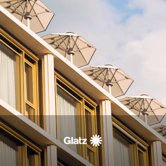 In einer Perspektive von unten nach oben schauend sind auf einem Dach stehen mehrere hellfarbenen, aufgespannte Schirme zu sehen. Am unteren Rand steht Glatz geschrieben.