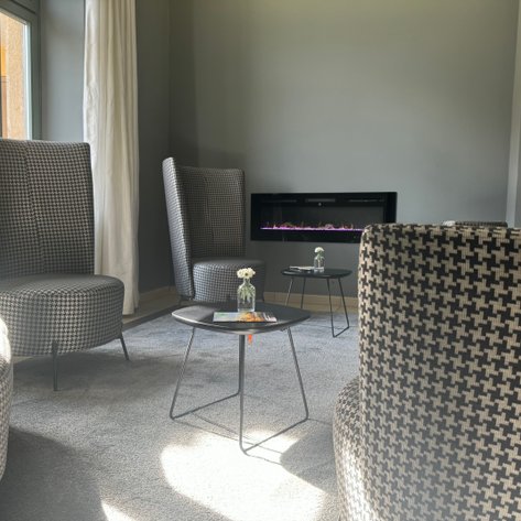 Gemütliche Sitzecke mit stilvollen, gepolsterten Sesseln und einem zeitgemäßen Tisch in einer modernen Lounge.