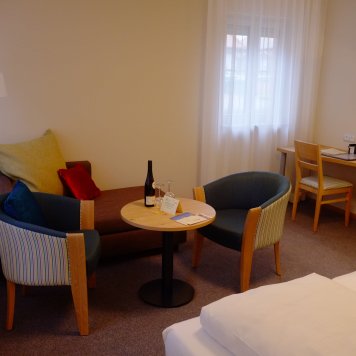 Ein stilvoll eingerichteter Raum mit einem Sofa, zwei Stühlen und einem Tisch, ideal für entspannte Momente.