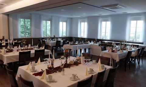 Helles, freundliches Ambiente mit schön eingedeckten Tischen, ideal für eine Feier oder Veranstaltung.