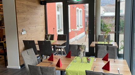 Helle und einladende Atmosphäre eines Restaurants, ausgestattet mit stilvollen Möbeln und geschmackvoller Dekoration.