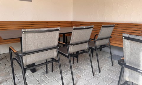 Ein einladender Außenbereich mit modernen Stühlen und einem Tisch, ideal für gesellige Zusammenkünfte oder Entspannung.