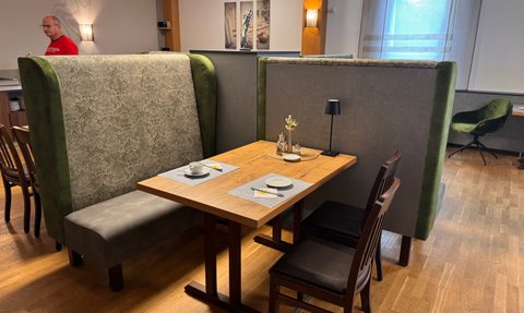 Gemütlicher Innensitzbereich mit gepolsterten Bänken und Tisch, ideal für entspannte Gespräche.