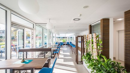 Die Inneneinrichtung des Lokals zeigt elegante Tische und Stühle, ergänzt durch eine offene Bar, die zur Geselligkeit einlädt.