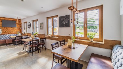 Ein einladendes Café mit einem rustikalen Dekor, wo natürliches Licht durch die Fenster strömt.