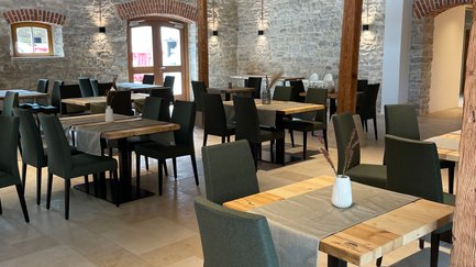Einladende Restaurantatmosphäre mit eleganten Tischen und Stühlen, die ein komfortables Essen versprechen.