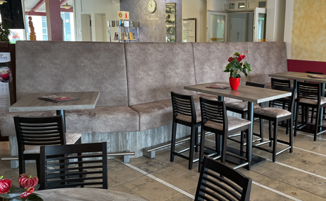 Restauranteinrichtung mit einer gepolsterten Sitzbank im Vintage-Lederlook.