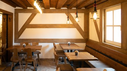 Eine gemütliche Restaurant-Ecke mit Holzstühlen und Tischen, die ein einladendes Ambiente schaffen.