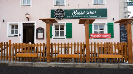 Das gemütliche Biergarten-Ambiente lädt mit Holzmöbeln und einer einladenden Fassade zum Verweilen ein.