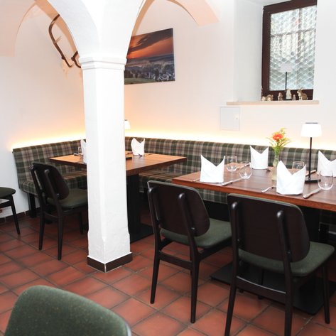 Ein gemütliches Restaurant mit eleganten Holztischen und eleganter Dekoration, bereit für Gäste.