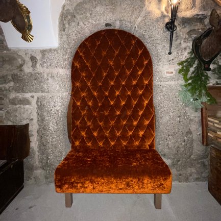 Eine elegante Sitzgelegenheit in Orange, umgeben von rustikalem Dekor, vermittelt ein behagliches Ambiente.