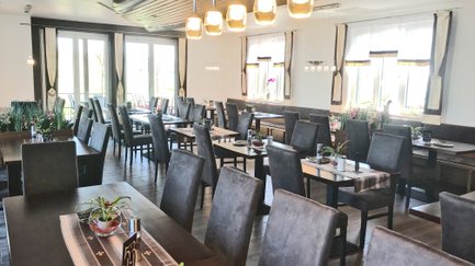 Restaurant-Innenraum mit Tischen und Stühlen mit Rückenpolsterung