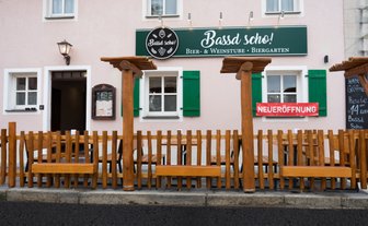 Das gemütliche Biergarten-Ambiente lädt mit Holzmöbeln und einer einladenden Fassade zum Verweilen ein.