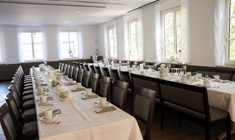 Helles, freundliches Ambiente mit schön eingedeckten Tischen, ideal für eine Feier oder Veranstaltung.