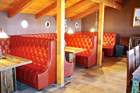 Gastraum mit roten gepolsterten Sitzbänken
