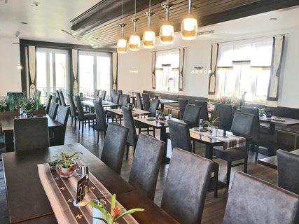 Restaurant-Innenraum mit Tischen und Stühlen mit Rückenpolsterung