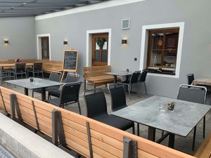 Empfangsbereich Jägerhof Modern möblierter Empfangs-Aussenbereich mit Tischen, Stühlen und Bänken aus Holz