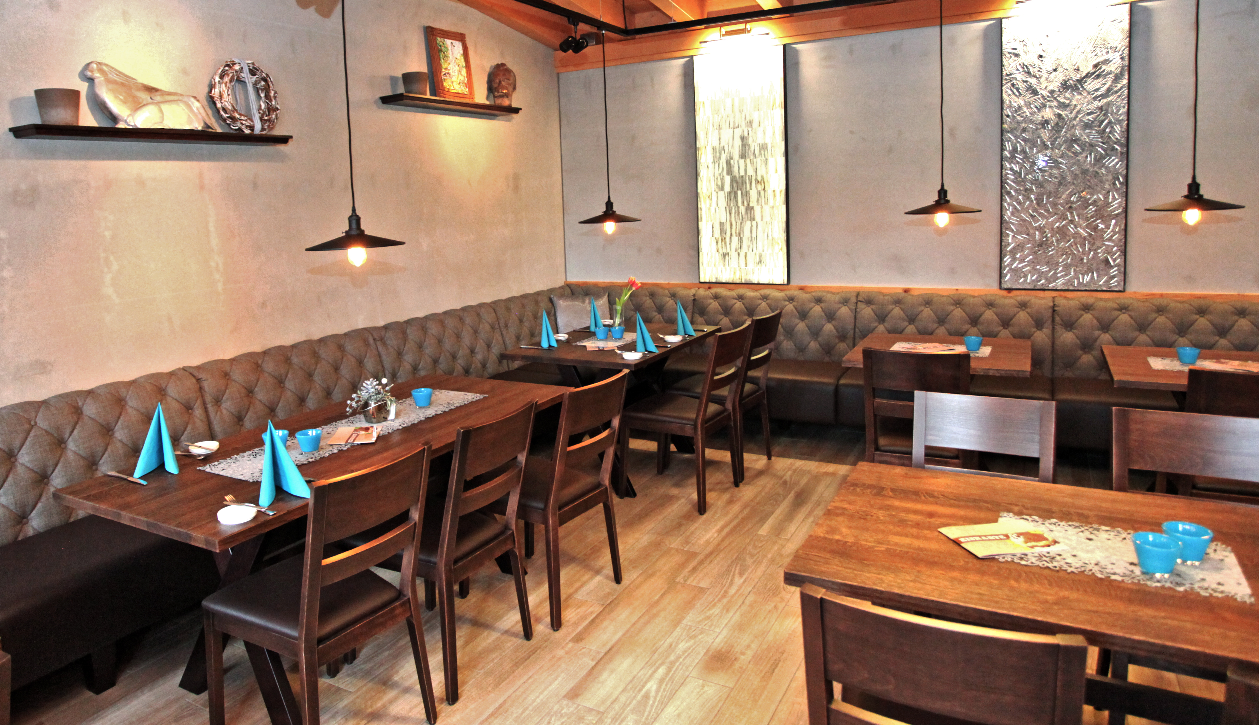 Restaurant-Innenraum mit Holztischen, Stühlen und Eckbank